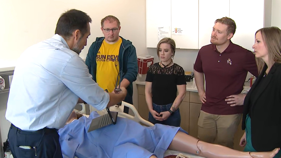 애리조나 주립대학교 간호대 출산 시뮬레이터 실습 장면 ASU 간호대학 교수와 학생 4명이 병원 실습실에서 첨단 출산 시뮬레이터를 함께 살펴보고 있다 (출처: FOX 10 Phoenix)